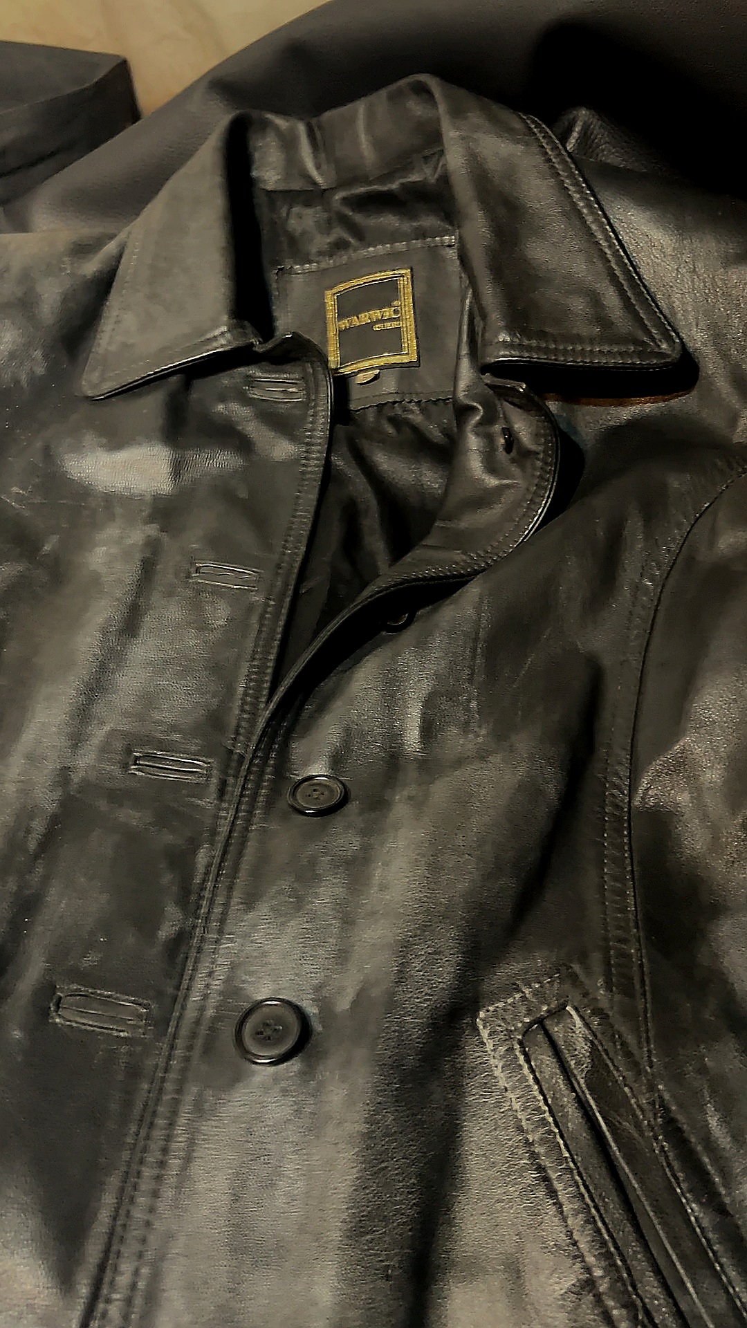 Detalle de la etiqueta y el frente de la campera clásica de cuero negro