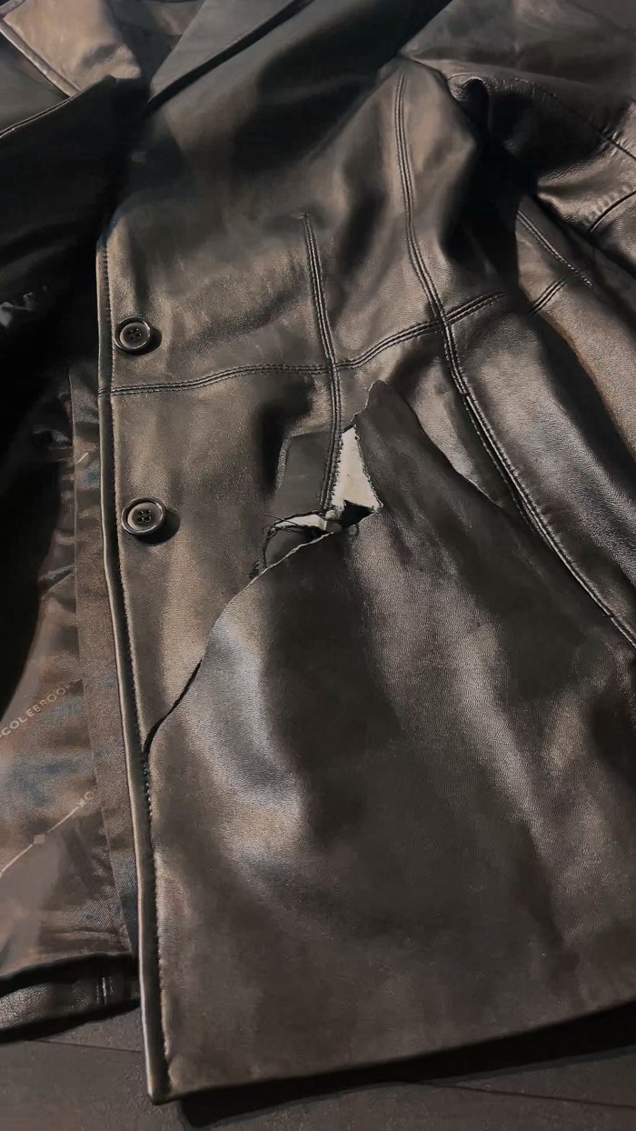 Detalle del desgarro en campera negra antes de restaurar