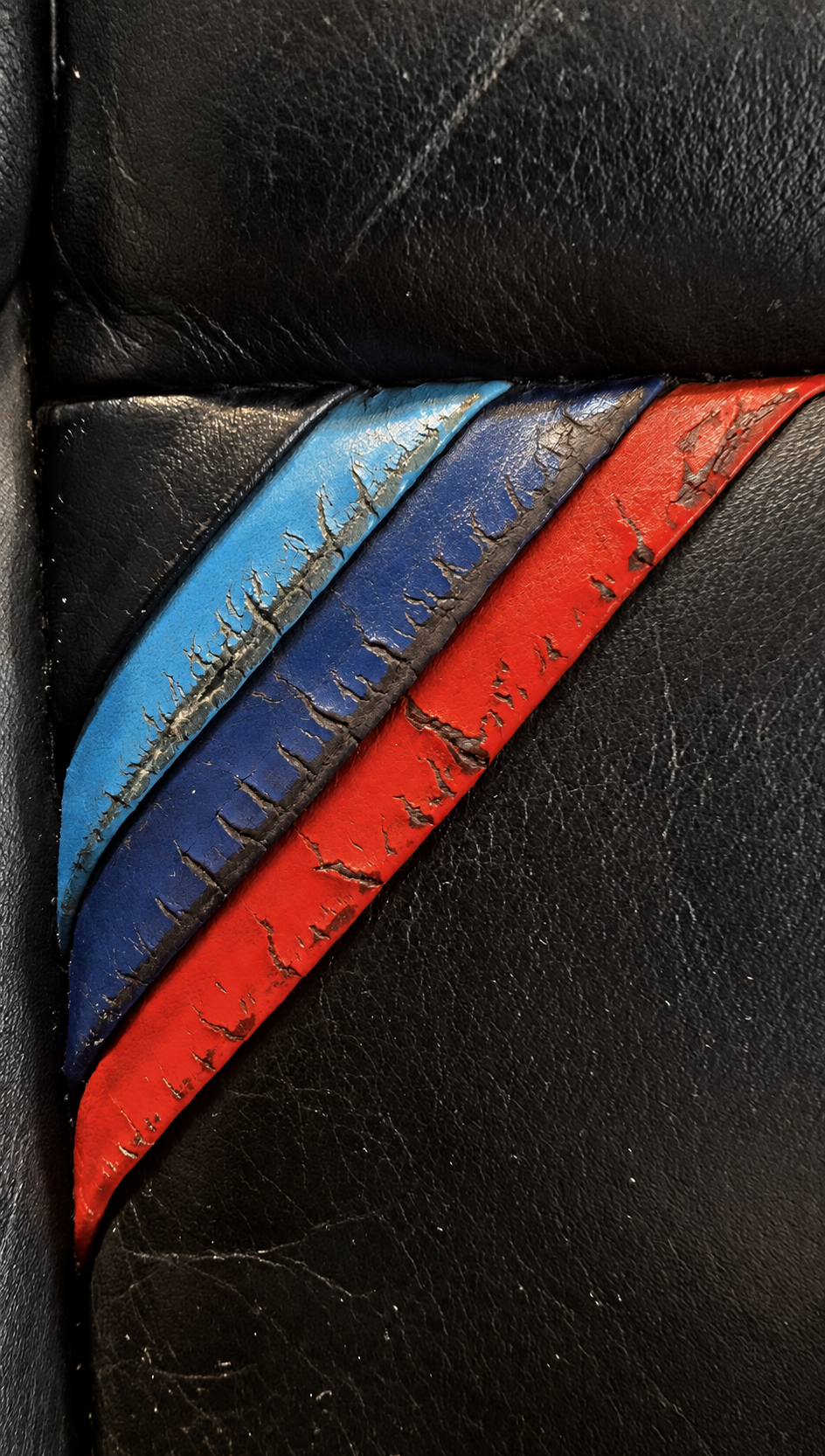 Detalle de tres colores deteriorados en asiento negro