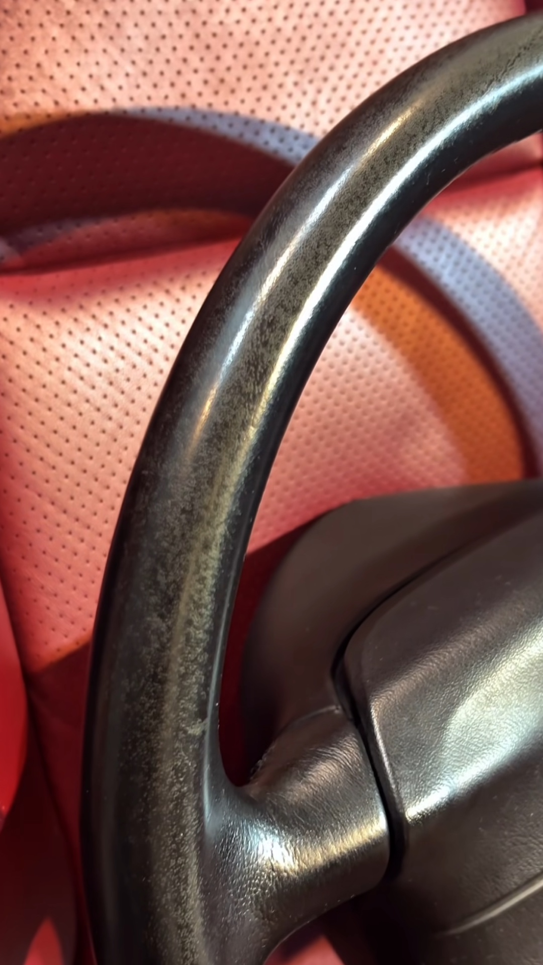 Detalle del volante antes de restaurar, sobre asiento de cuero rojo